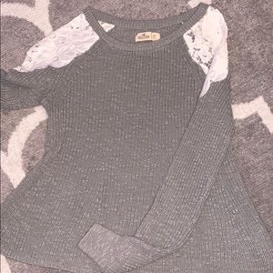 Grey sweater with open sleeves.